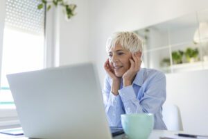 Portrait of casual woman using her laptop while sitting home office and working. An attractive middle aged businesswoman sitting in front of laptop and managing her small business from home.